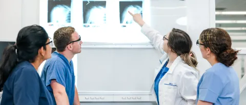 Medical students examine an x-ray in a lab