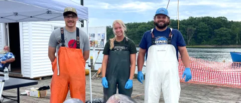 Three marine science students pose on the pier at Camp Ellis along the Saco River
