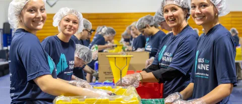 Students help make Meals for Maine food kits.