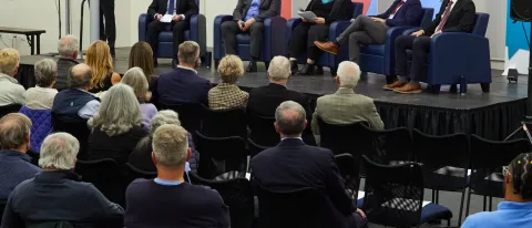 UNE President James Herbert introduces four panelists and a moderator onstage