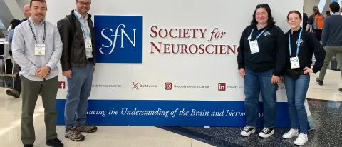 A group of UNE researchers pose in front the Society for Neuroscience sign