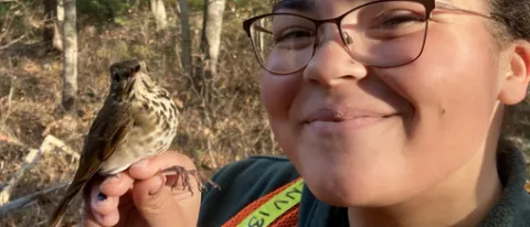 Haley Hines holds a wild bird that Professor Noah Perlut's class will band. 