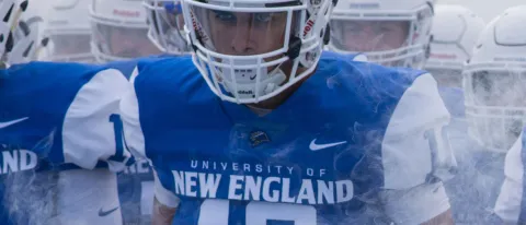 UNE football team members walk through the fog