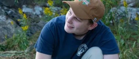 A UNE student smiles while working in the field
