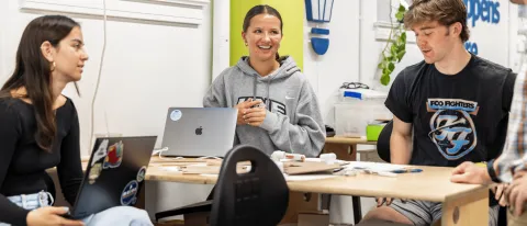 Three UNE students work around a table in the Makerspace