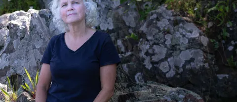 UNE's Pam Morgan poses against a rocky outcropping