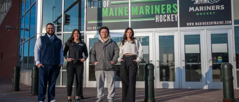 UNE students pose in front of the Cross Insurance Arena in Portland