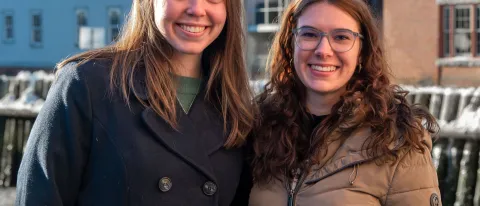 Two women pose in front of the Portland waterfront
