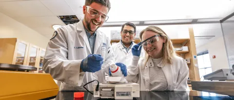 UNE faculty member Sri Mohan works with students in his lab