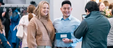 Two students pose for a photo holding a Match Day envelope