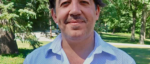 Moustafa Abu El Fadl smiles outside on a sunny day