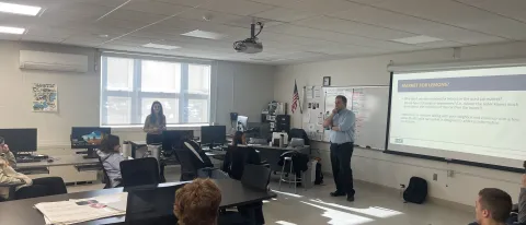 UNE's Tim Potsaid presents a slideshow to a group of high school students