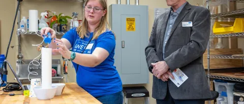 A student displays a marine research device fashioned from PVC pipes