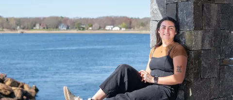 Morgan Bassett sits at Jordan's Point on UNE's campus