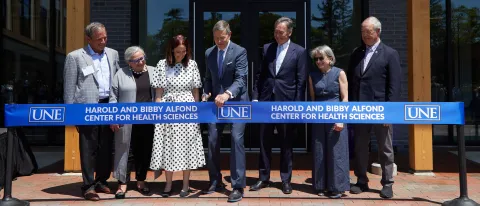 UNE administrators and trustees cut the ribbon for the Harold and Bibby Alfond Center for Health Sciences