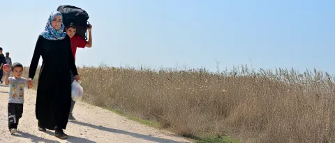 A woman and her family walk down a dirt path