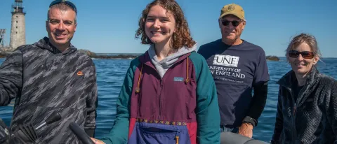 A UNE student poses in a group in 