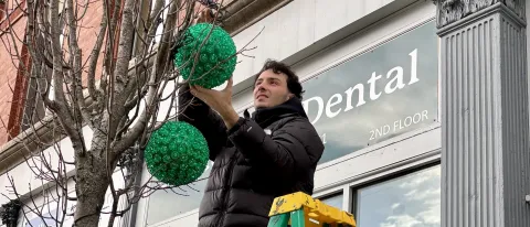 UNE students hang holiday lights, help provide holiday cheer in downtown Biddeford 
