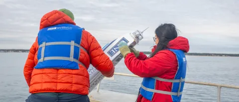 UNE student Jasmin Townsend-Ng (’26) assists Dr. Kochtitzky in lower a buoy