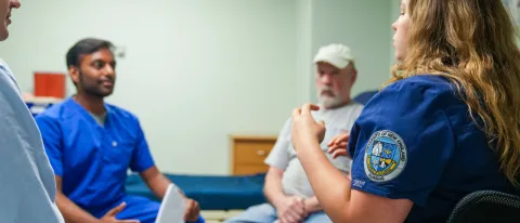 Health care students discuss care options in UNE's simulation lab