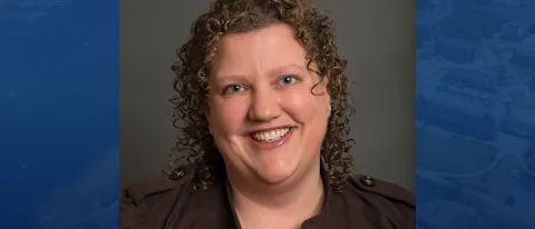 Headshot of Elizabeth Crampsey against blue background