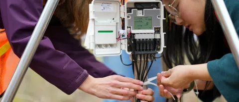 Students tie off a weather monitoring system 