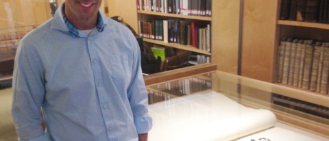 Noah Perlut stands beside Bowdoin College’s copy of the double-elephant folio edition of Audubon’s Birds of America. The red-he