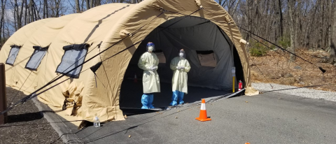 Third-year UNE COM students Matt DiOrio (left) and Katelyn Chadwick (right) stand outside a drive-thru COVID-19 testing facility
