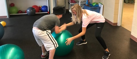 UNE student Meghan Cookson works with a child at the Finding the Pieces Camp