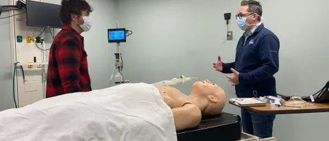 Baxter Academy engineering teacher Jon Amory chats with UNE's Neill Gemmel in the simulation lab