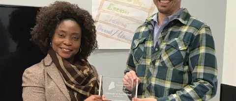 FedCap Biddeford Site Manager Sianeh Omeze presents UNE with the Education Partner Award, accepted by Ian Imbert, M.P.H.