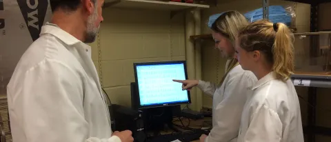 Glenn Stevenson works with students Katherine Cone and Abigail Kinens in the lab.
