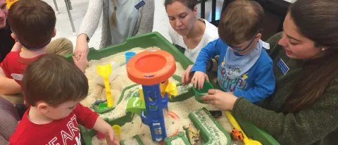 Occupational Therapy and Physical Therapy students engage with children at the sand table during Playgroup