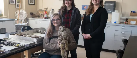 Students Teagan Bollman (holding owl) and Jillian Henrichon with Emma White (right), instructor of the Museum Specimen Preparati