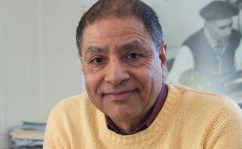 Portrait of man in yellow sweater smiling at camera