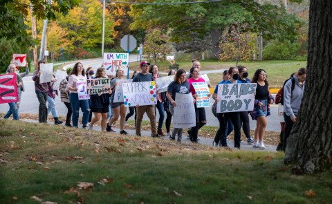 A group of students march through campus