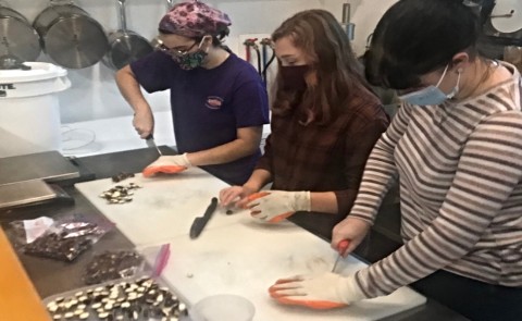 Students Virginia May, Kate Ganley, and Jocelyn LaClair remove chestnuts from their shells