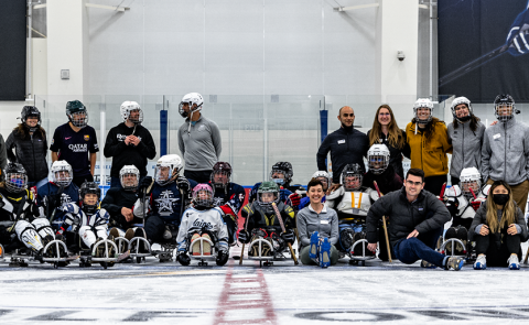 A group of PT students and volunteers/participants from Maine Adaptive post after a sled hockey demonstration at the Harold Alfond Forum