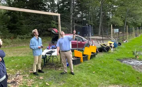 A group of students sends off a drone to monitor an orchard of American chestnut seedlings
