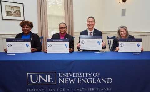 UNE and Cheyney University officials, including UNE President James Herbert and UNE COM Dean Jane Carreiro, hold signed copies of the articulation agreement
