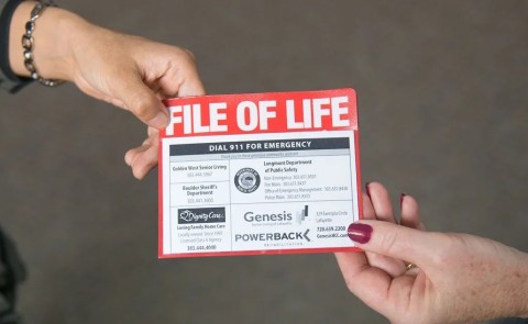 The File of Life pamphlet is shown being handed between two people