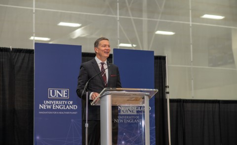 president herbert stands at podium during fall assembly