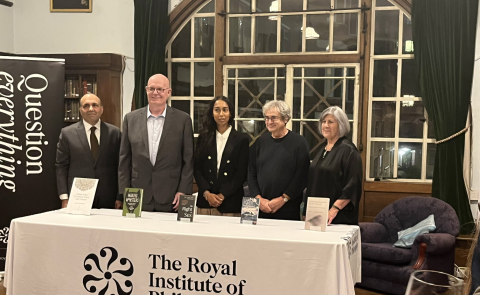 A photo of the prize finalists standing behind a table bearing the Royal Institute of Philosophy's name and logo