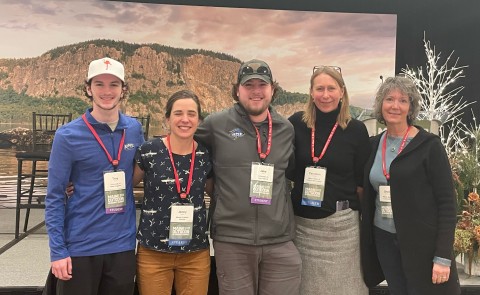 UNE students Troy Fowler and Jake Tobin pose with representatives from Maine's outdoor economy at the Maine Outdoor Economy Summit in Rockland