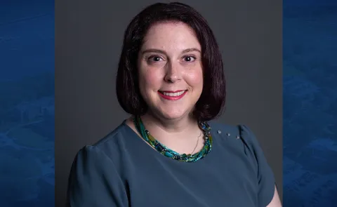 Headshot of Dana Villmore against a blue background