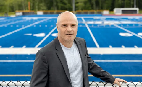 Portrait of Norm O'Reilly with the UNE football field in the background
