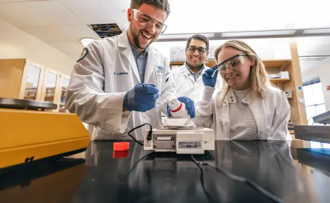 UNE faculty member Sri Mohan works with students in his lab