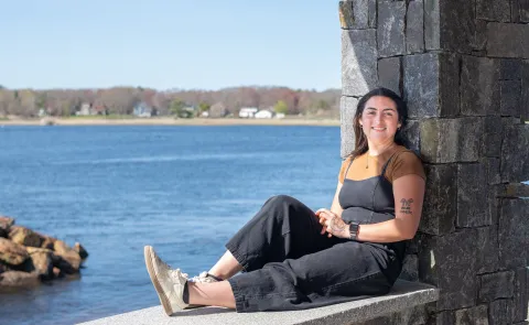 Morgan Bassett sits at Jordan's Point on UNE's campus