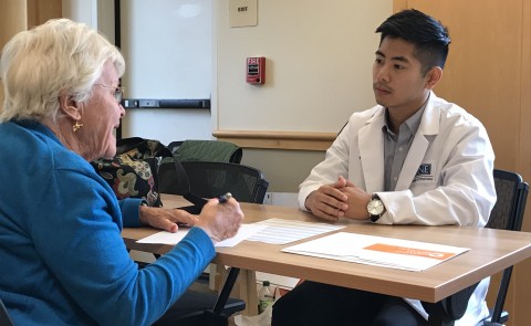 College of Pharmacy student Brian Lui chats with clinic attendee Jane Gleason about her medication