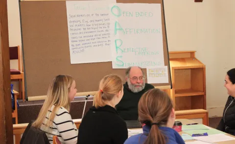 UNE health professions students talk with actor Bob Pettee, who plays the role of a patient during SBIRT training